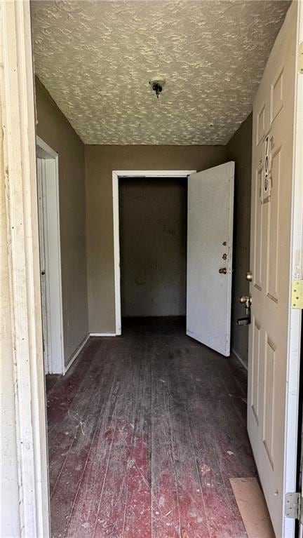 Empty room featuring hardwood / wood-style flooring and a textured ceiling