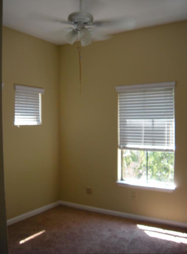 Carpeted spare room featuring ceiling fan and bas