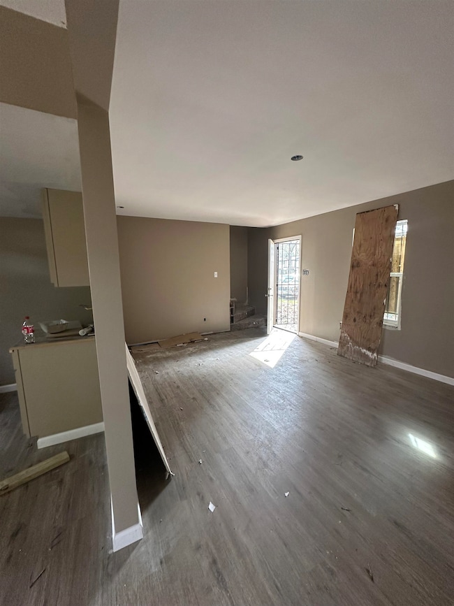 Unfurnished living room with baseboards and wood finished floors
