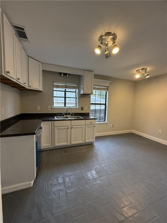 Kitchen featuring a sink, brick patterned floors, 