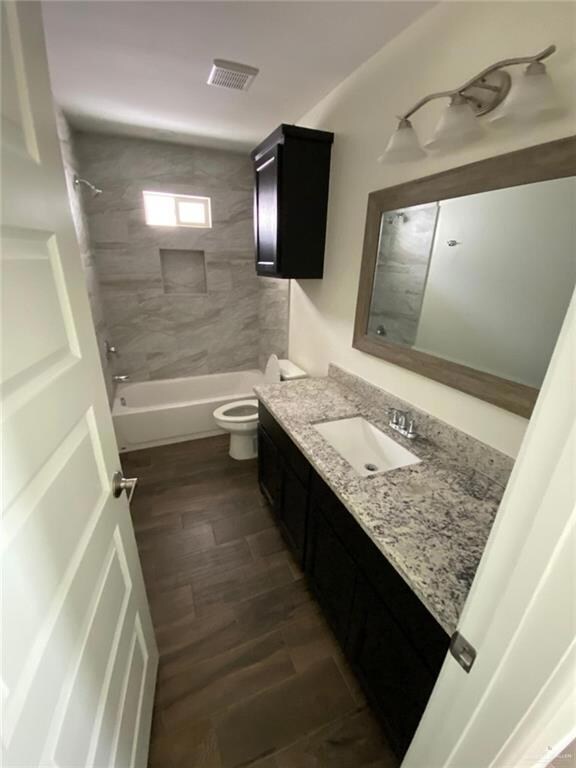 Full bath featuring vanity, tub / shower combination, and wood finished floors