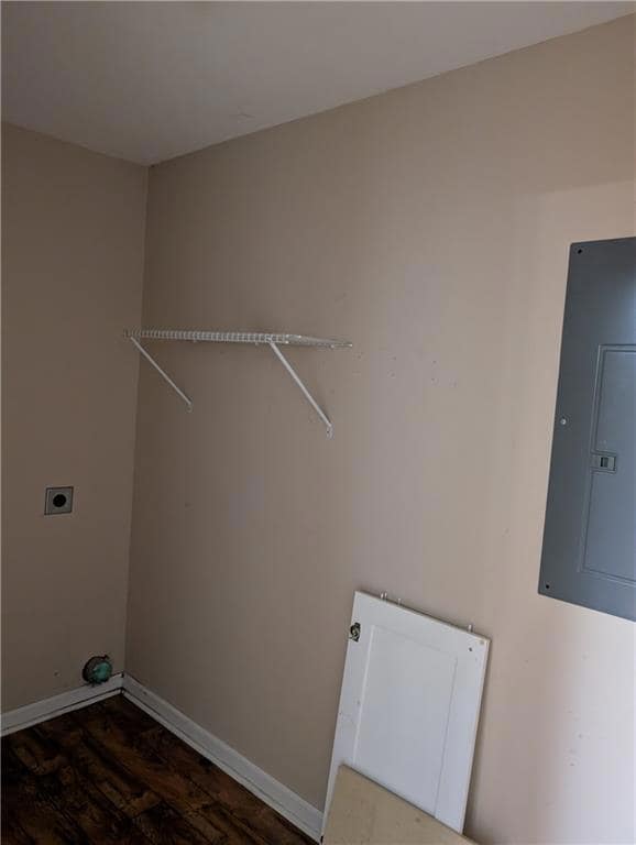 Washroom with electric dryer hookup, electric panel, and wood finished floors