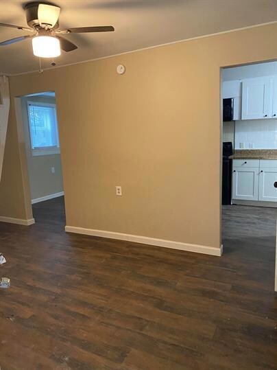 Spare room with baseboards, dark wood finished fl