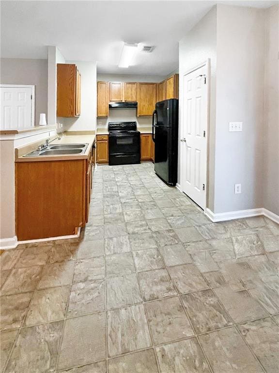 Kitchen featuring black appliances, a sink, under cabinet range hood, brown cabinetry, and light countertops