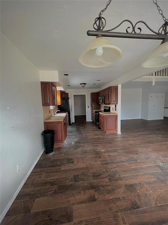 Unfurnished living room featuring dark wood-type f