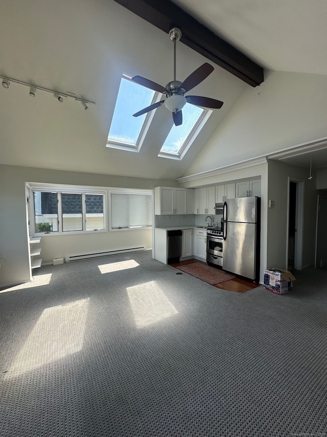 spacious large room with open sun-filled living area, nook, & kitchen.