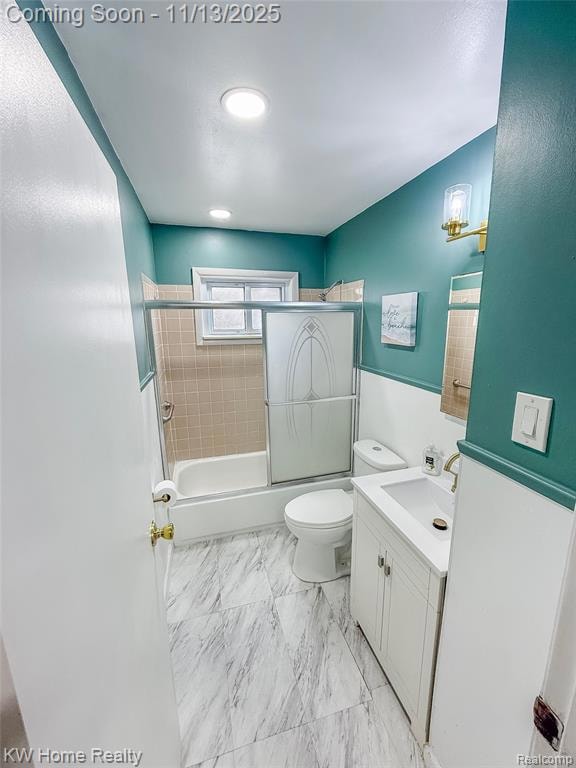 Bathroom featuring vanity and shower / bath combination with glass door