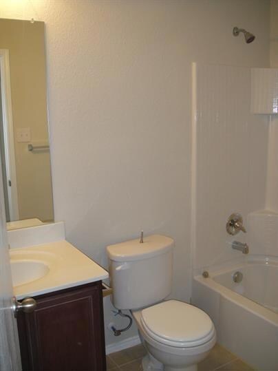 Full bathroom with tile flooring, shower / washtub combination, vanity, and toilet
