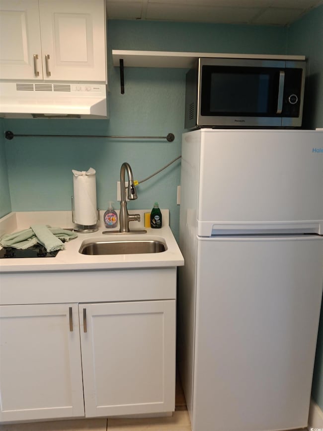 Kitchen featuring a sink, freestanding refrigerato