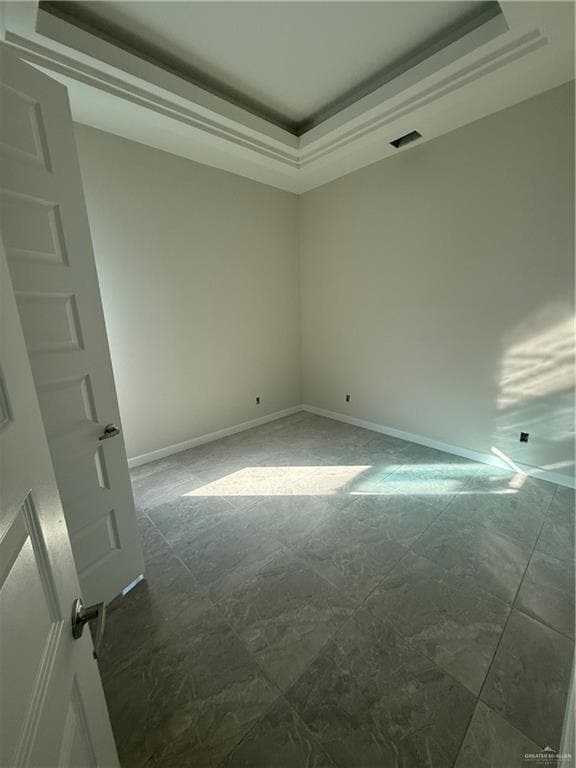 Unfurnished room with a raised ceiling