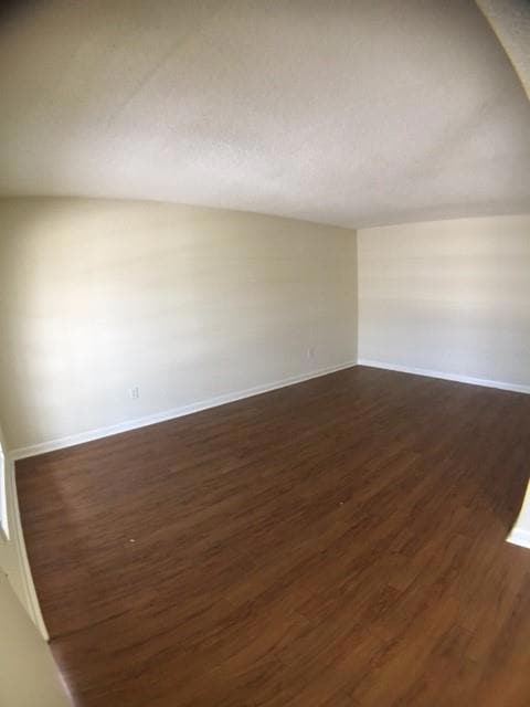 Unfurnished room featuring baseboards, a textured