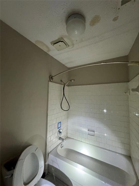 Bathroom with toilet, tiled shower / bath combo, a