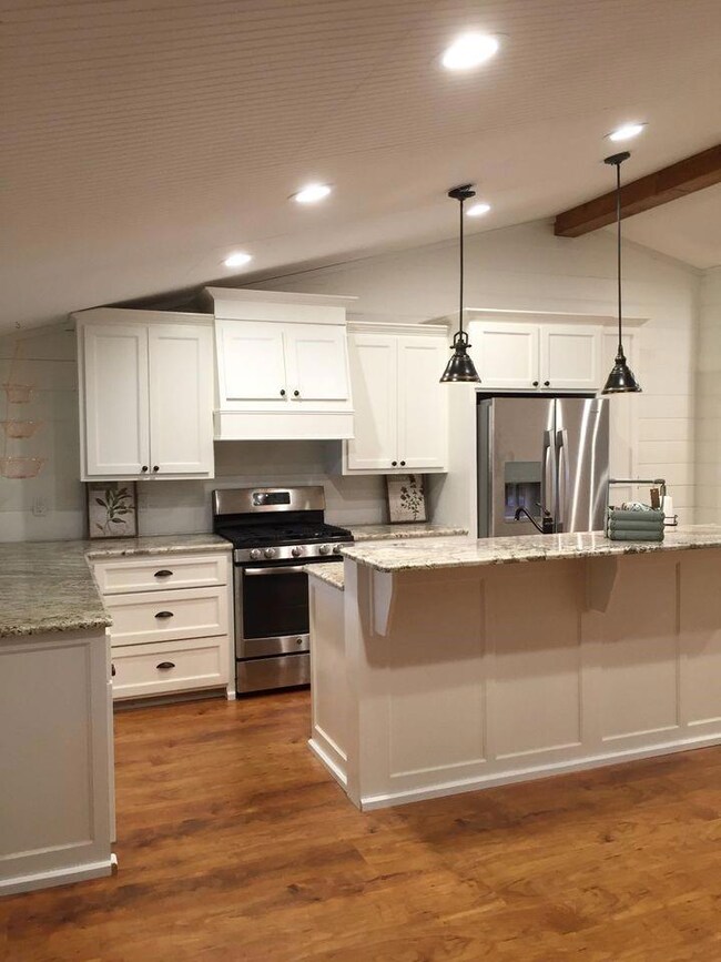 Kitchen with lofted ceiling with beams, dark hardw