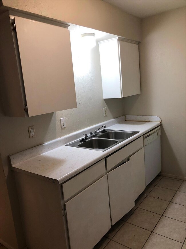 Kitchen featuring light tile patterned floors, sin