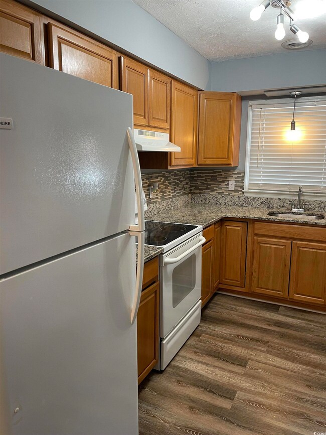 Kitchen with backsplash, a textured ceiling, sink,