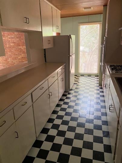 Kitchen with dark flooring, freestanding refriger