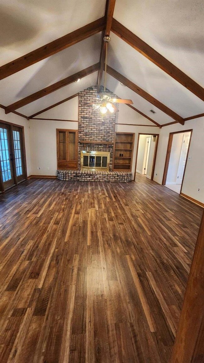 Unfurnished living room featuring a ceiling fan, l