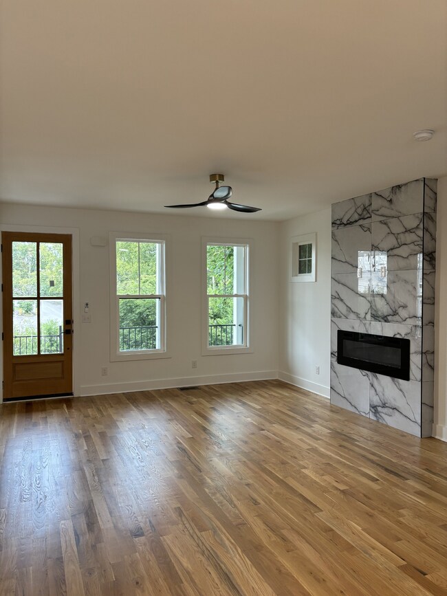 Another view of the Great Room with beautiful wood floors and electric fireplace.