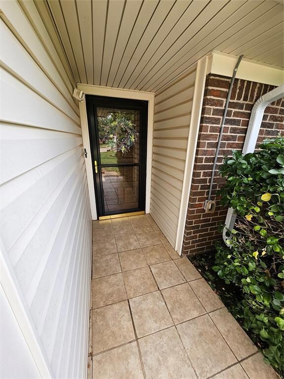 Property entrance featuring brick siding