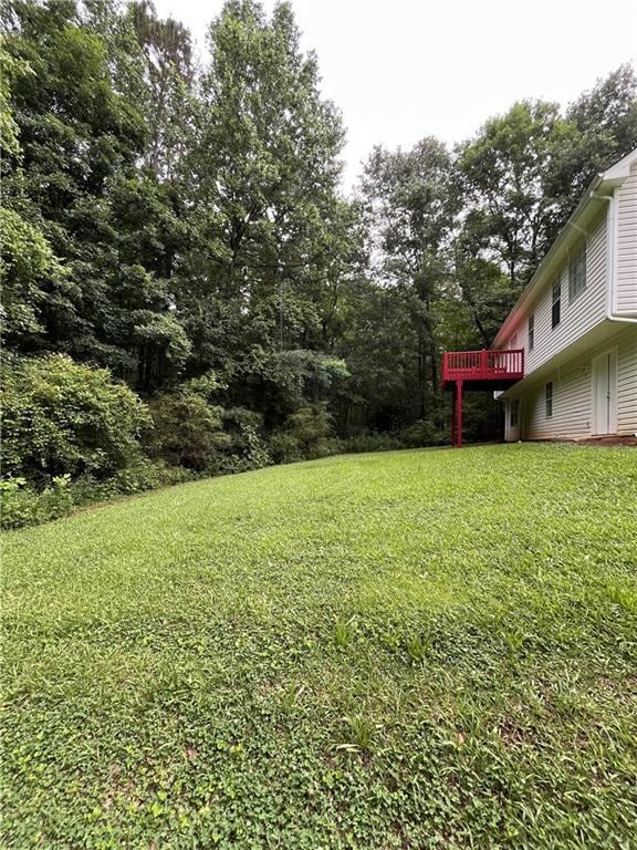 View of green lawn featuring a deck