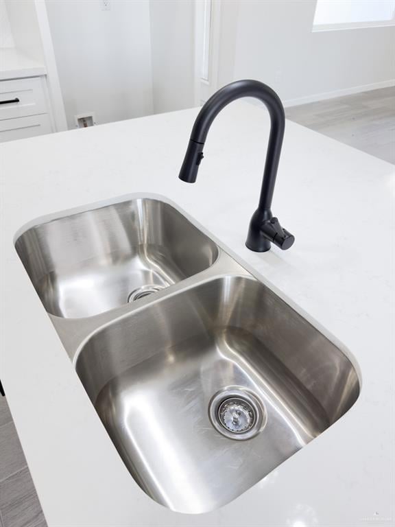 Room details with white cabinets and sink