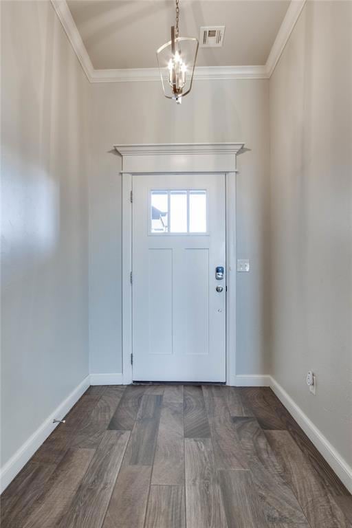 Entryway with crown molding, a chandelier, and dark wood-style flooring