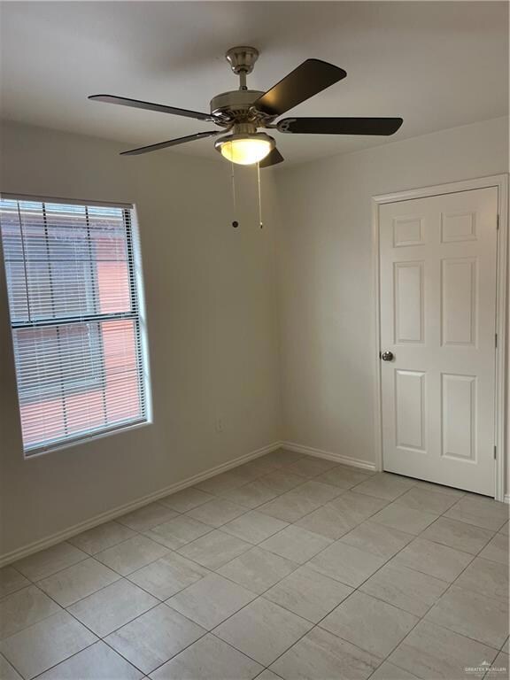 Spare room featuring light tile patterned floors and a ceiling fan