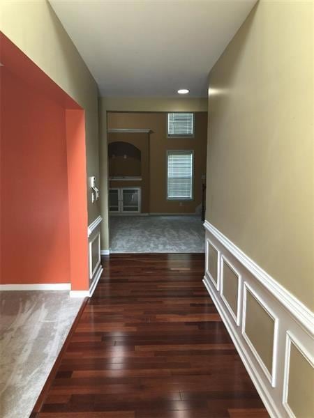 Corridor featuring arched walkways, a wainscoted w