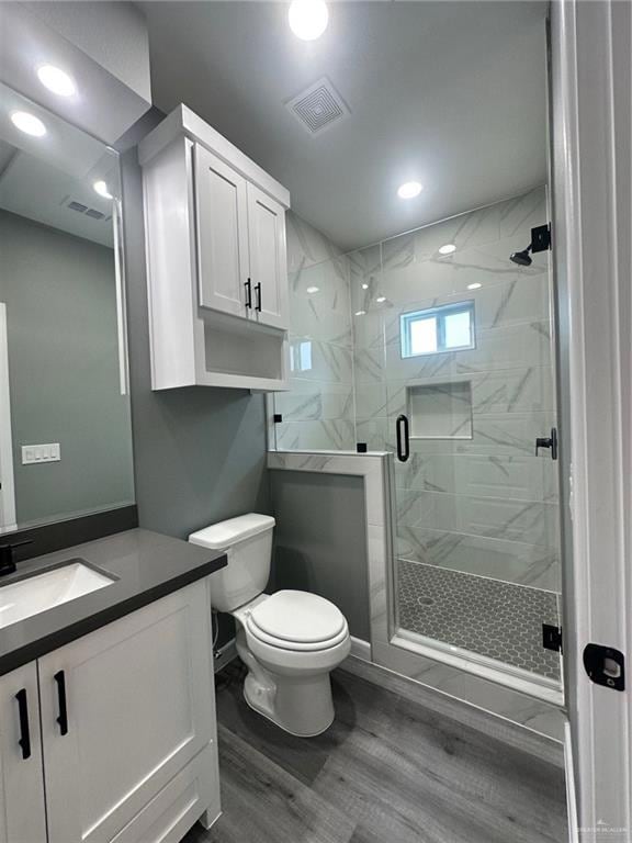 Full bathroom with a marble finish shower, vanity, and recessed lighting
