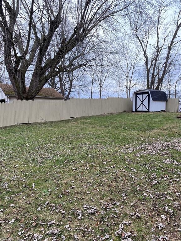 Another view of the fenced in back yard w/ shed.