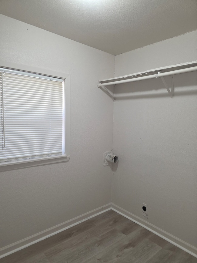 Washroom featuring light wood-type flooring and a textured ceiling
