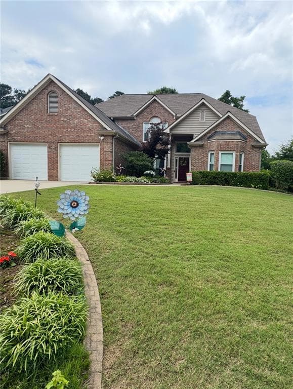 View of front of property featuring brick siding, a front lawn, and a garage