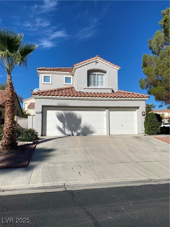 Mediterranean / spanish home featuring concrete driveway, stucco siding, a tile roof, and an attached garage
