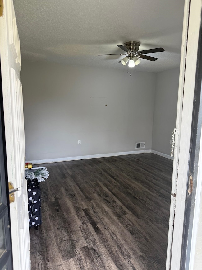 Living room with a ceiling fan, dark wood-style fl