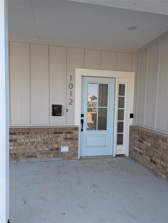 Doorway to property with a patio area