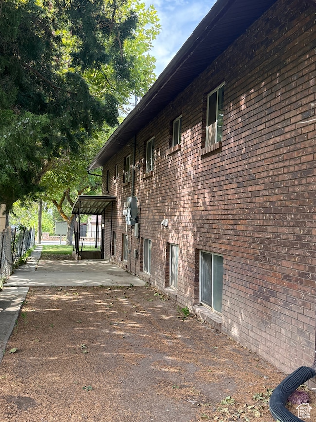 View of side of property featuring brick siding and patio.