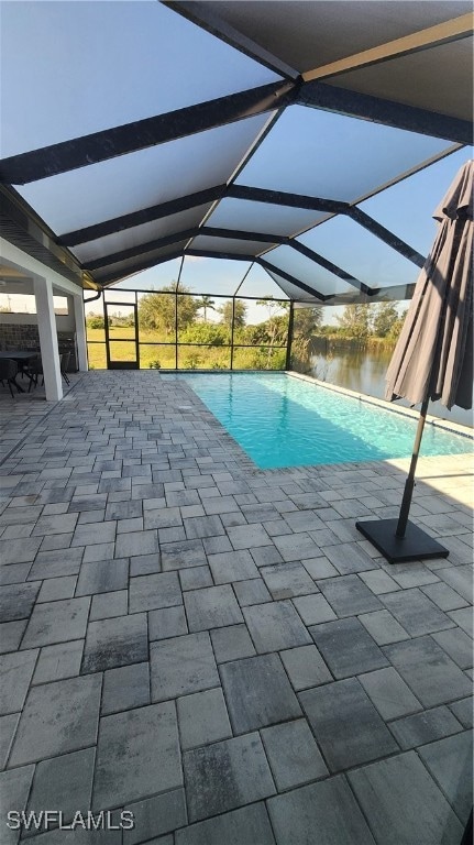 View of swimming pool featuring a water view, a pa