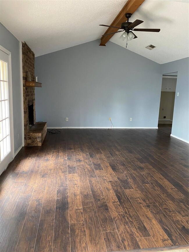 Unfurnished living room featuring a textured ceili