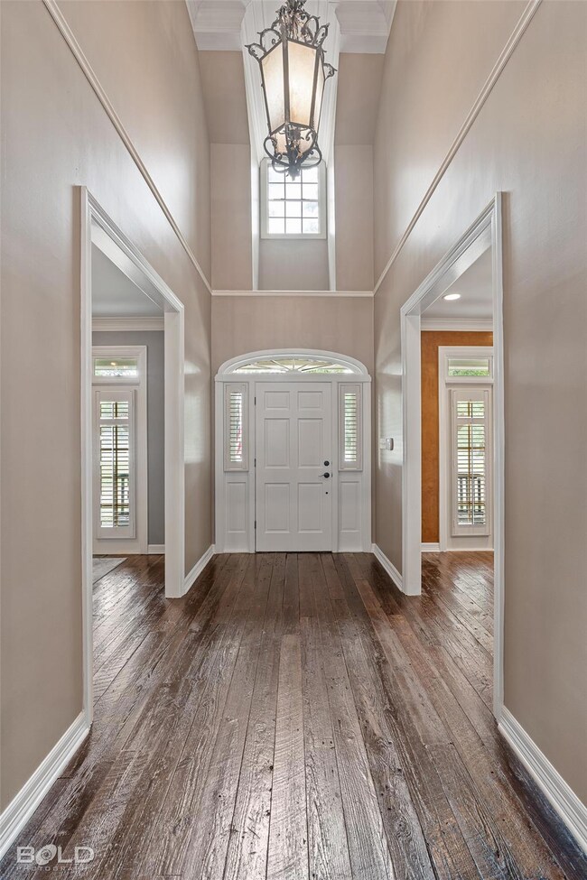 Entrance foyer with crown molding, a notable chand