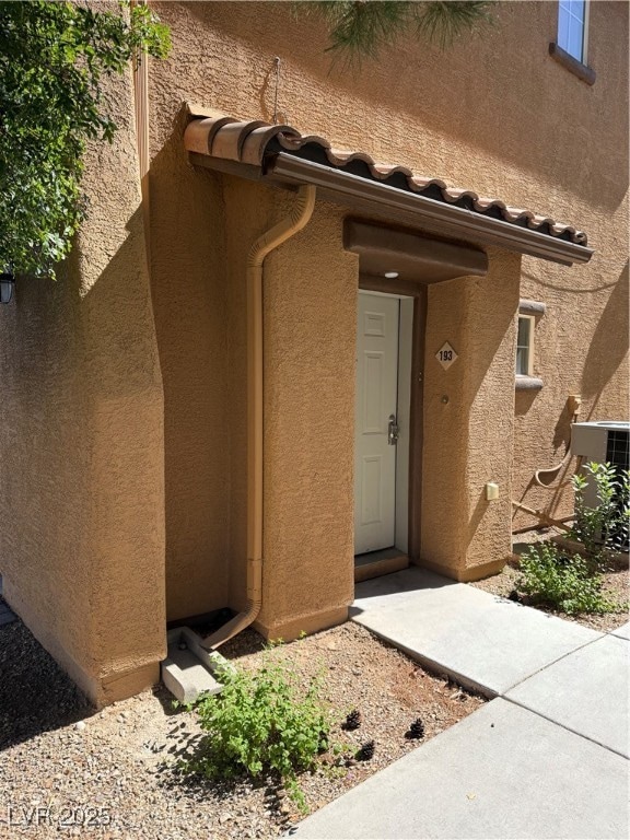 View of exterior entry with central air condition