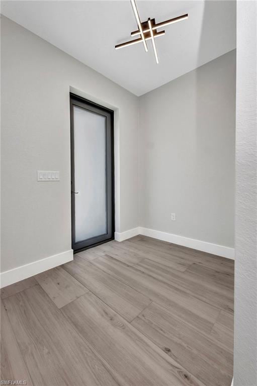 Unfurnished room featuring baseboards and wood fin