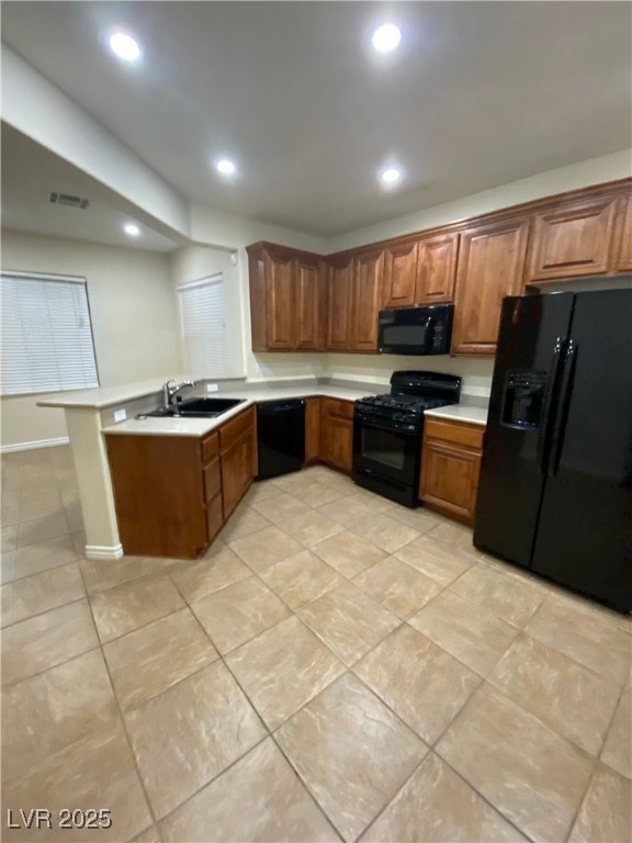 Kitchen with a sink, brown cabinetry, black applia