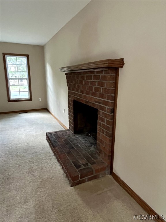 Unfurnished living room featuring carpet and a bri