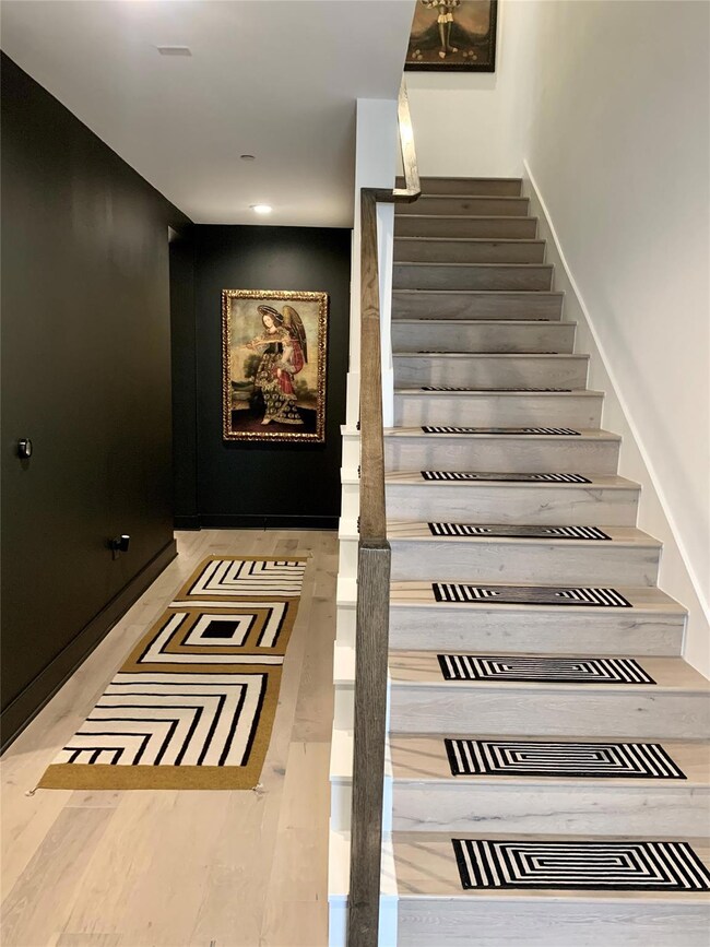Staircase with wood finished floors and recessed 