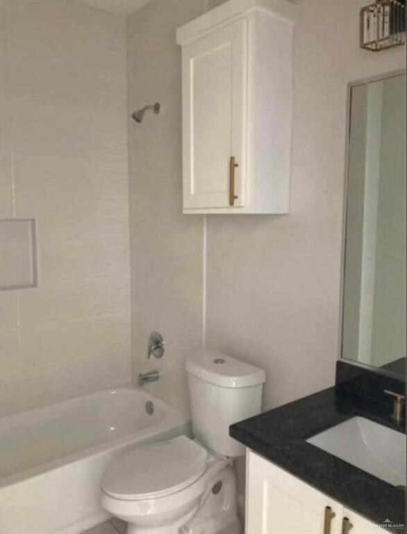 Full bathroom featuring vanity, toilet, and tiled shower / bath combo