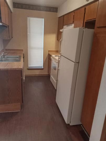 Kitchen with brown cabinets, dark wood-type floor