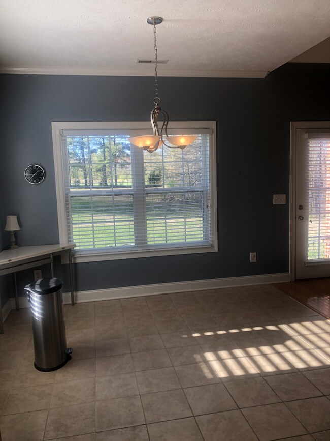 Dining area with large windows viewing the backyard and opens into the living room area.