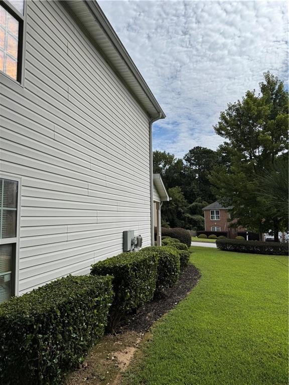 View of side of home featuring a yard