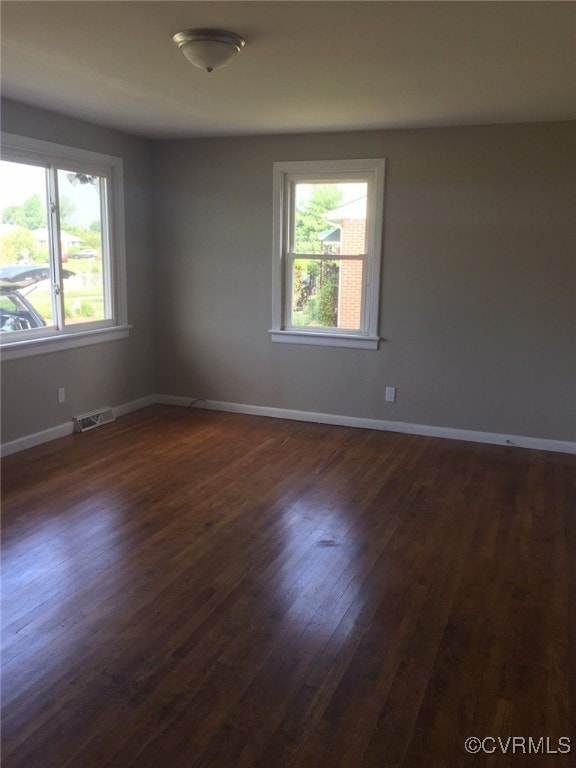 Spare room featuring dark wood-style flooring and