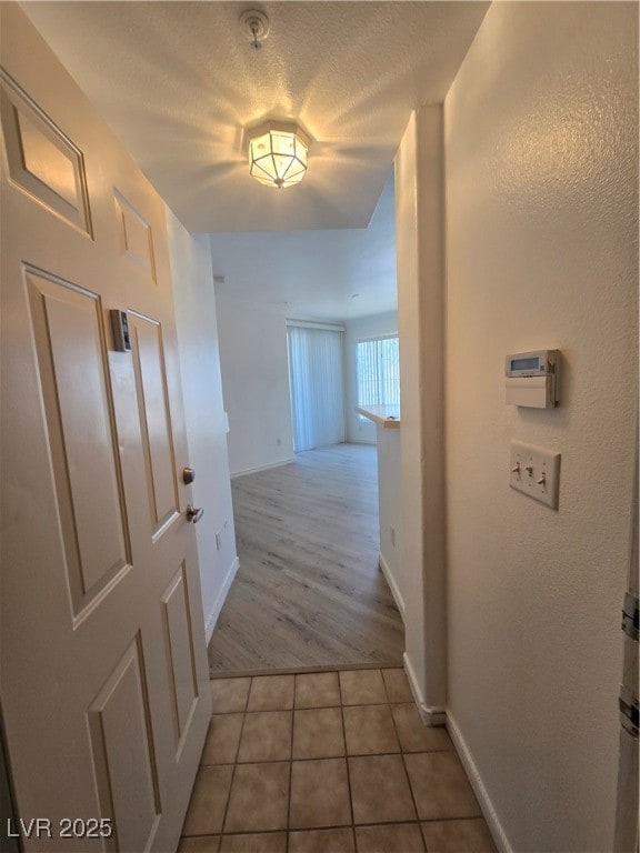 Hallway featuring light tile patterned flooring an